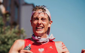uśmiechnięty i zmęczony biegacz biegnie finish