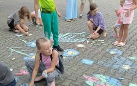 dzieci malują kredą po kostce