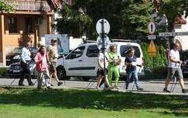 osoby podczas nording walkingm, w tle budynki