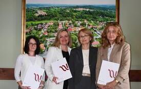 osoby stojące z dyplomami
