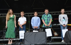 laureaci konkursu fotograficznego na scenie, prowadząca i 4 osoby