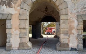 brama zamkowa z rozpiętym wężem strażackim