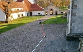 Dziedziniec zamkowy z rozpiętym węzem strażackim, biegnący strażak