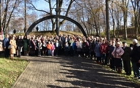 zdjęcie pamiątkowe wszystkich uczestnik&oacute;w na tle pomnika