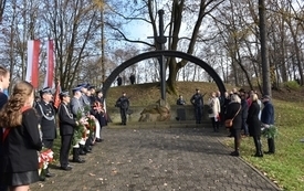 uczestnicy pod pomnikiem, widać też flagi Polski