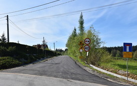 droga, znaki, domy w oddali