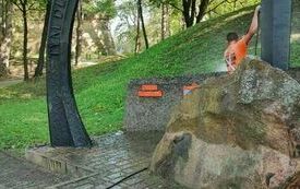 z przodu głaz za nim pracownik i pozostała część pomnika