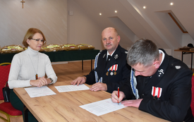 Burmistrz, Prezes i strażak podpisują dokumenty