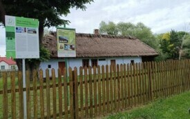 tablice i dom w oddali, drewniany płot