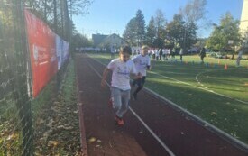 dw&oacute;ch chłopc&oacute;w biegnie, w tle inne osoby, drzewa