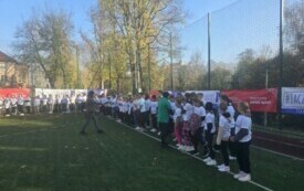 zawodnicy ustawieni jeden obok drugiego w linii, dw&oacute;ch nauczycieli