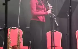 dziewczynka w czerwonej bluzce gra na klarnecie