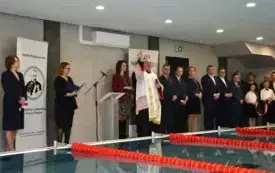 ksiądz kropi pomieszczenie wodą święconą
