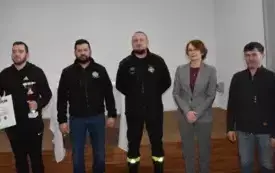 strażak z pucharem i dyplomem oraz wręczający