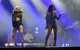 piosenkarka w czarnym kostiumie śpiewa, w tle tancerka