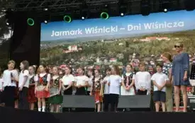 grupa dzieci śpiewa na scenie piosenkę