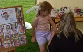 kobieta maluje dziecku obrazek na ręce