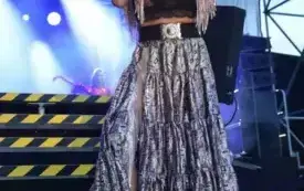 kobieta w cygańskiej sukni śpiewa do mikrofony na schodach na scenę