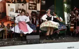 zesp&oacute;ł w strojach ludowych tańczy na scenie