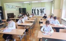 dzieci w ławkach piszą test