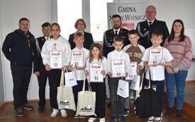 dzieci z dyplomami i nagrodami, druhowie OSP w mundurach, burmistrz 