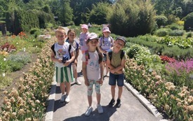 dzieci idą alejką, kwiaty w około