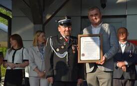 Stanisław Bukowiec z podziękowaniem, inne osoby obok