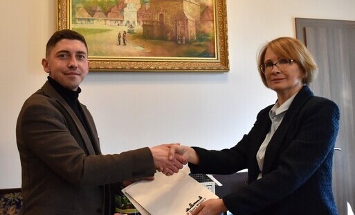 właściciel firmy podaje rękę burmistrz