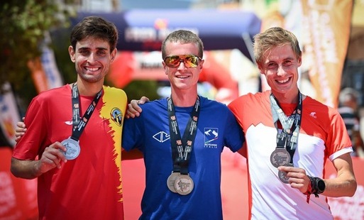 trzech mężczyzn z medalami na szyji pozuje do zdjęcia