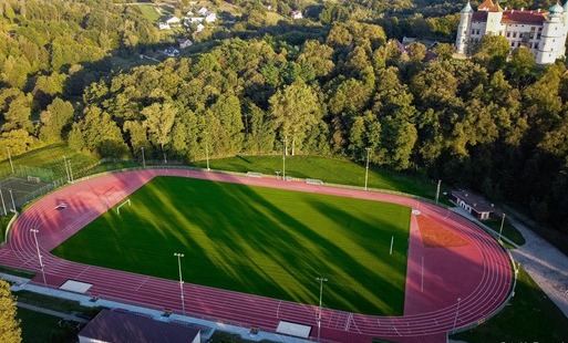 widok na stadion z drona. po prawej stronie zamek, drzewa, domy w oddali